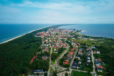 High angle view of townscape by sea against sky