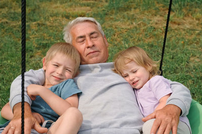 Portrait of happy family sitting on hammock