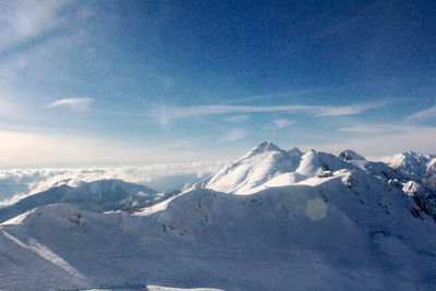 Scenic view of snowcapped mountains against blue sky