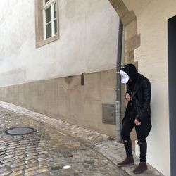 Full length of man standing against brick wall