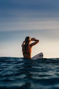 Man with woman in sea against sky