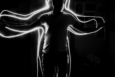 Man with light painting in darkroom