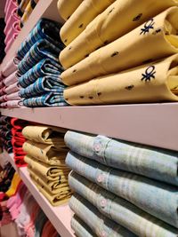 High angle view of multi colored shirts on shelf