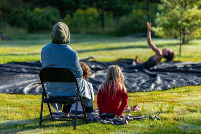 Rear view of people sitting on grass