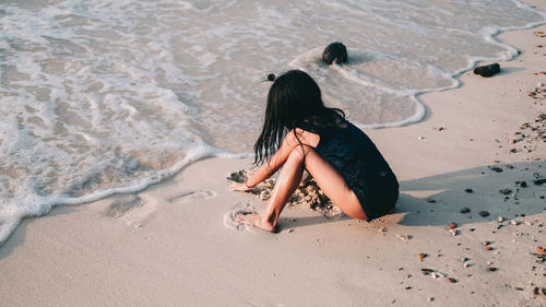 High angle view of woman sitting on beach