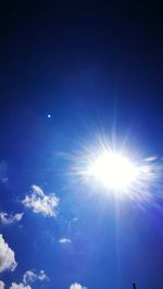 Low angle view of sun shining in blue sky