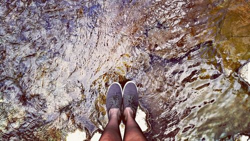 Low section of woman standing in water