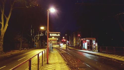 Illuminated railroad tracks against sky at night