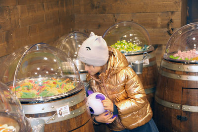 Young woman looking at jar on table