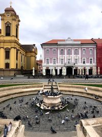 Buildings in city against cloudy sky