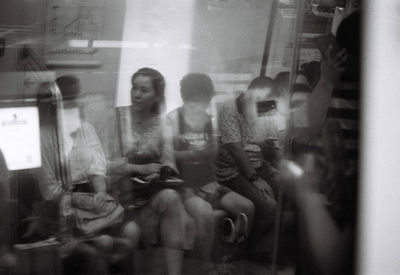 Digital composite image of woman sitting in glass window