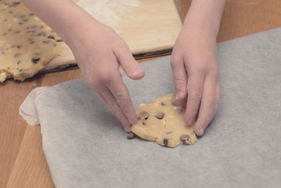 Cropped hands of woman making cookies on table