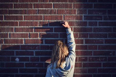 Woman standing against brick wall