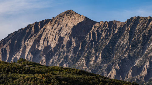 Full frame panoramic view of jagged mountains against blue sky