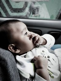 Close-up of cute baby girl sitting in car