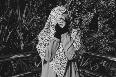 Woman standing against plants