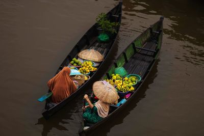 High angle view of people sitting by lake