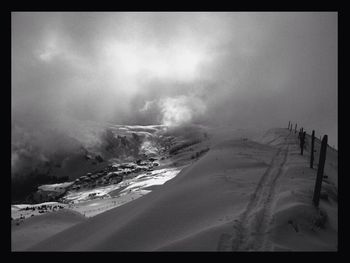 Panoramic view of snow covered land against sky