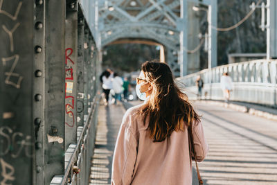 Rear view of woman walking on bridge