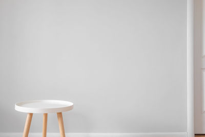 Close-up of empty chair on table against wall