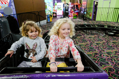 Two girls on rollercoaster looking with anticipation and happiness