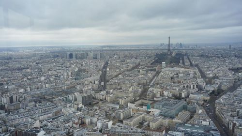 Aerial view of cityscape against cloudy sky