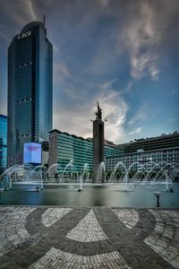 View of modern building against cloudy sky