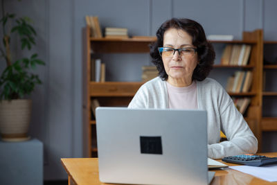 Portrait of woman using laptop at table
