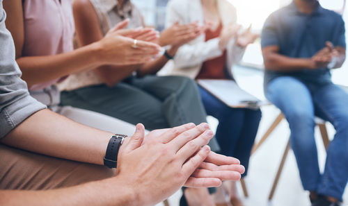 Midsection of business people stacking hands