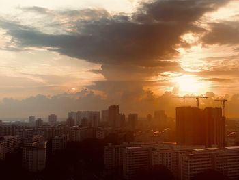 Modern buildings in city against sky during sunset