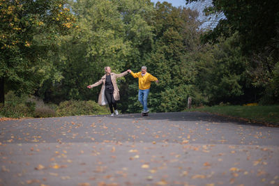 A couple rides a skateboard