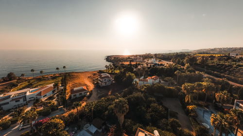 High angle view of townscape by sea against sky during sunset