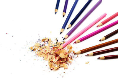 High angle view of multi colored pencils on white background