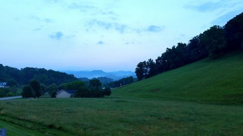 Scenic view of grassy field against cloudy sky