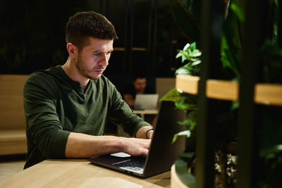 Young man using laptop at table