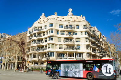 Cars on street by building against sky