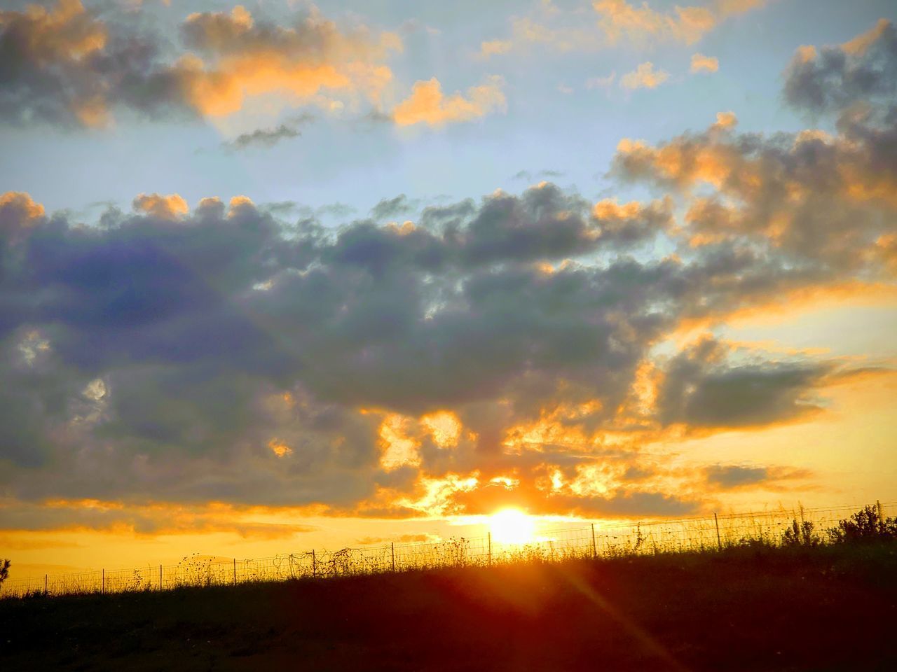 SCENIC VIEW OF SUNSET OVER SILHOUETTE LANDSCAPE AGAINST SKY