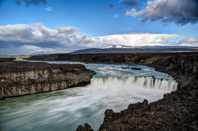 Scenic view of waterfall against sky