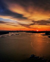 Scenic view of sea against dramatic sky during sunset