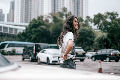 Smiling young woman on road in city