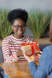 Portrait of young woman holding gift box