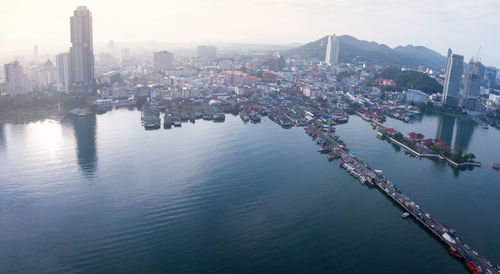 High angle view of city by river against sky