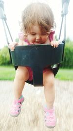 Close-up of boy playing with pink while sitting outdoors