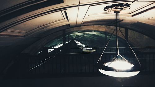 Low angle view of illuminated lamp hanging on ceiling