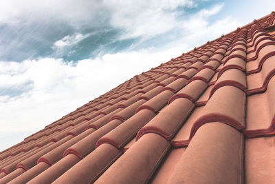 Low angle view of roof tile against cloudy sky