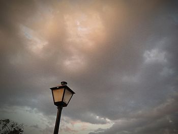 Low angle view of lamp against dramatic sky