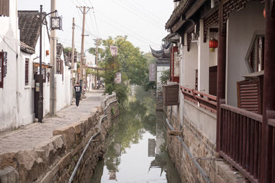 Canal amidst buildings against sky