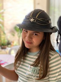 Portrait of girl wearing hat sitting at home