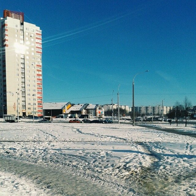 building exterior, built structure, architecture, snow, winter, cold temperature, clear sky, blue, street, road, transportation, electricity pylon, sky, city, power line, street light, electricity, season, outdoors, house