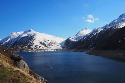 Scenic view of snowcapped mountains against blue sky